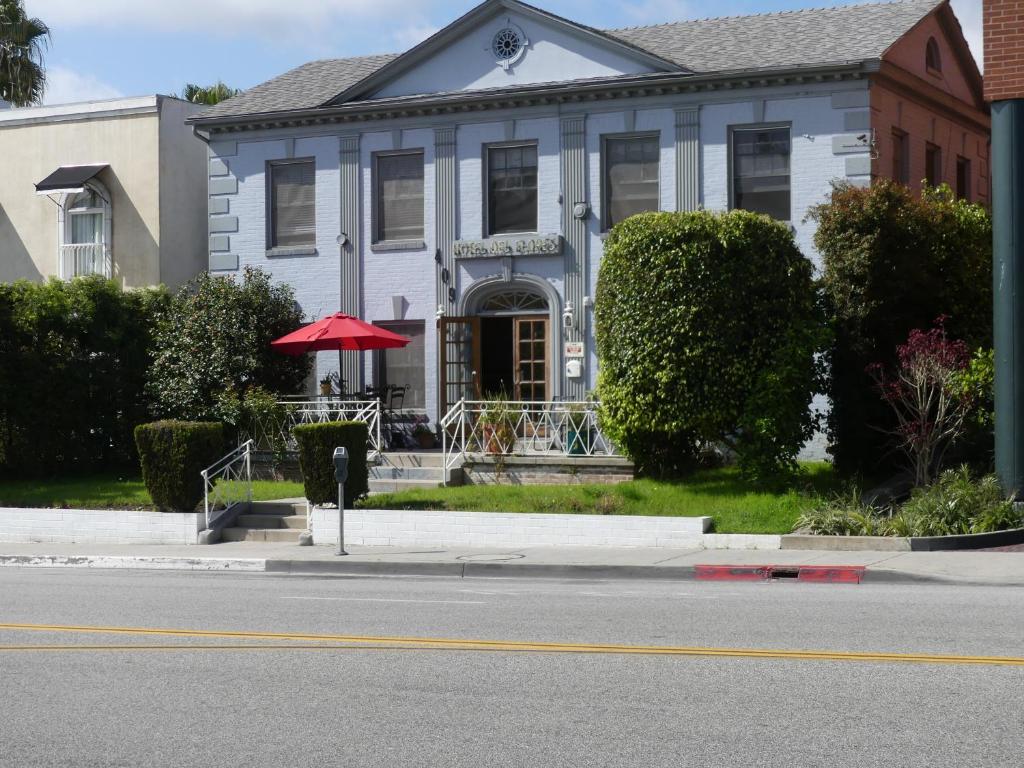 a blue house with a red umbrella in front of it at Hotel del Flores in Los Angeles