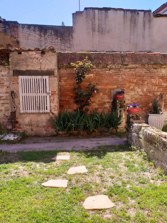 eine Backsteinmauer mit einem Tor im Hof in der Unterkunft Auberge des chemins in Moissac