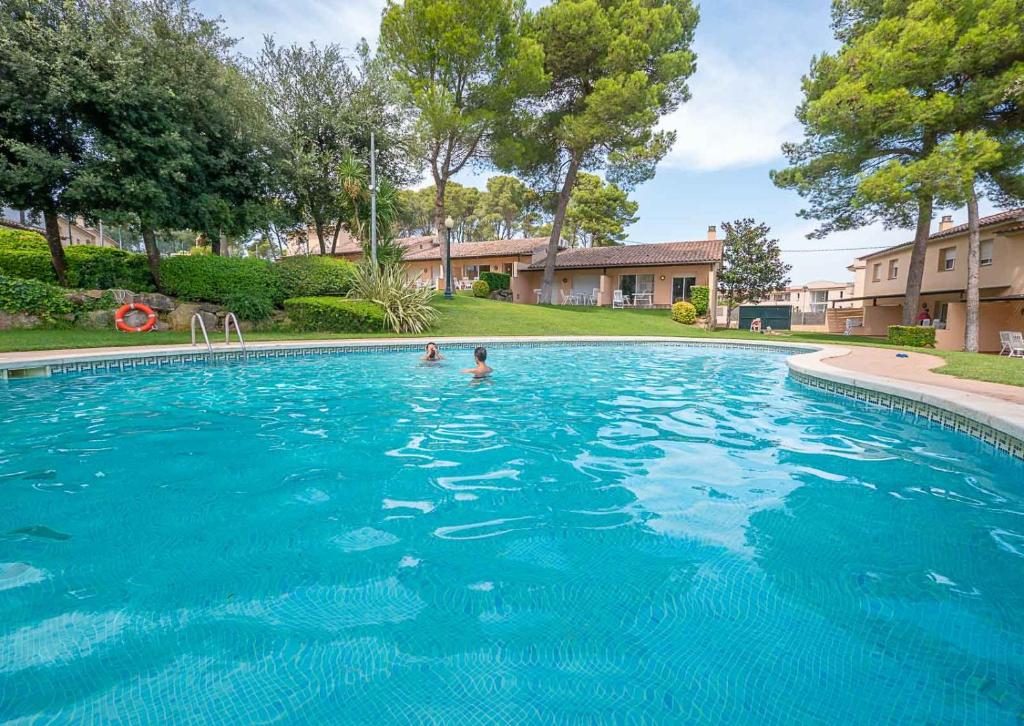 ein Schwimmbad mit zwei Personen im Wasser in der Unterkunft Village Golf Beach in Pals