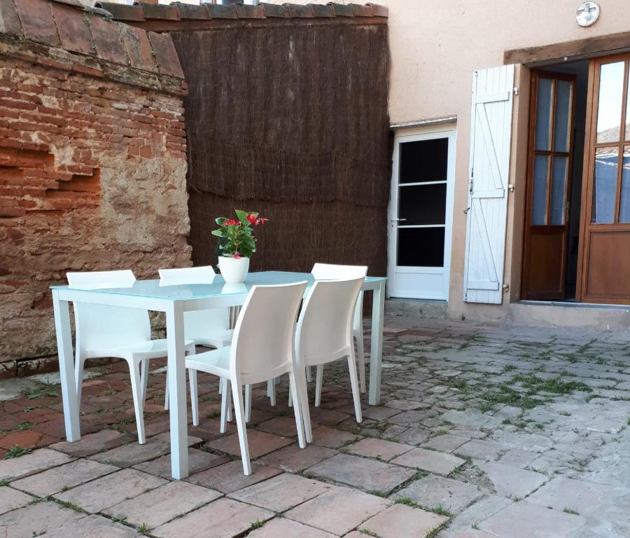 a white table and chairs on a patio at Auberge des chemins in Moissac