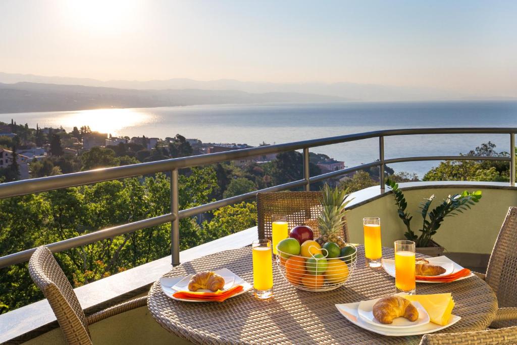 a table with a bowl of fruit on a balcony at Smart 4 Sports Apartment in Opatija