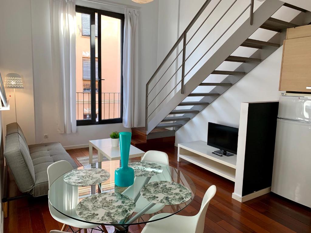 a living room with a glass table and a staircase at Petit Palomar - PalomarGroup in Valencia