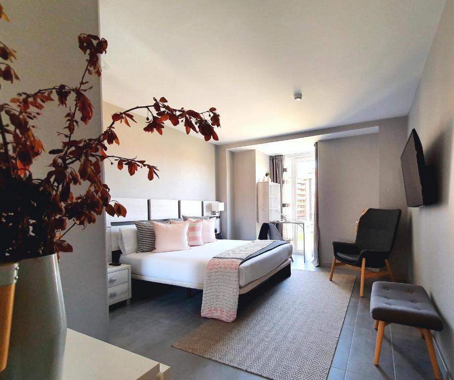 een hotelkamer met een bed en een stoel bij Apartahotel 5dos5 in Oviedo