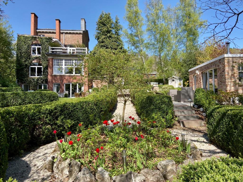 a garden in front of a house with flowers at Villa Louise in Stavelot