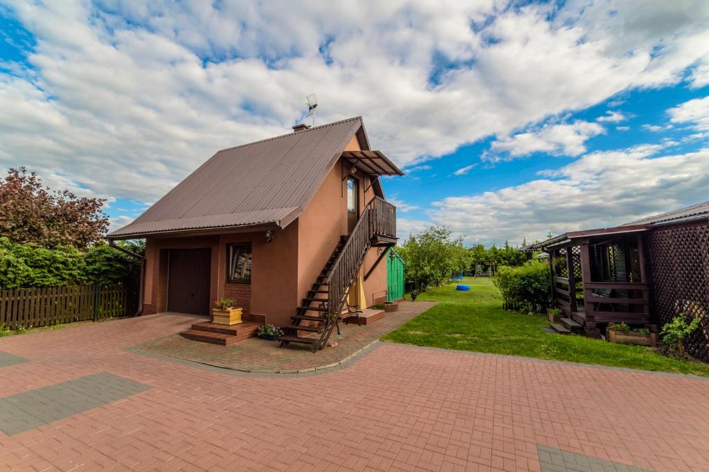 mały dom z metalowym dachem na podjeździe z cegły w obiekcie Pensjonat Jagoda w Piszu