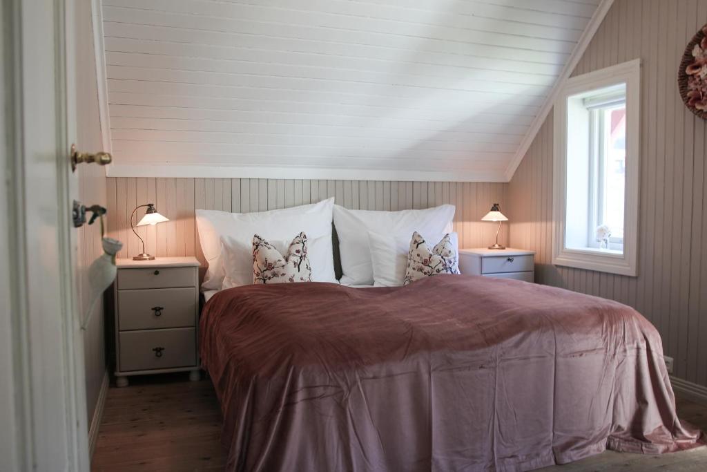 ein Schlafzimmer mit einem großen Bett mit zwei Nachttischen in der Unterkunft Petrines Gjestgiveri in Norddal