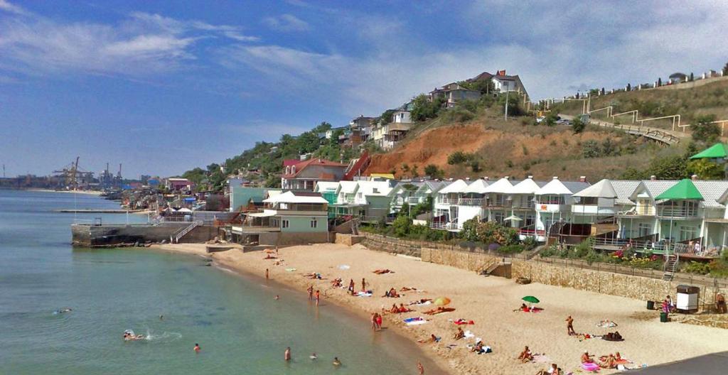 una playa con un montón de gente en el agua en Совиньон. Коттедж. Первая линия. en Odesa