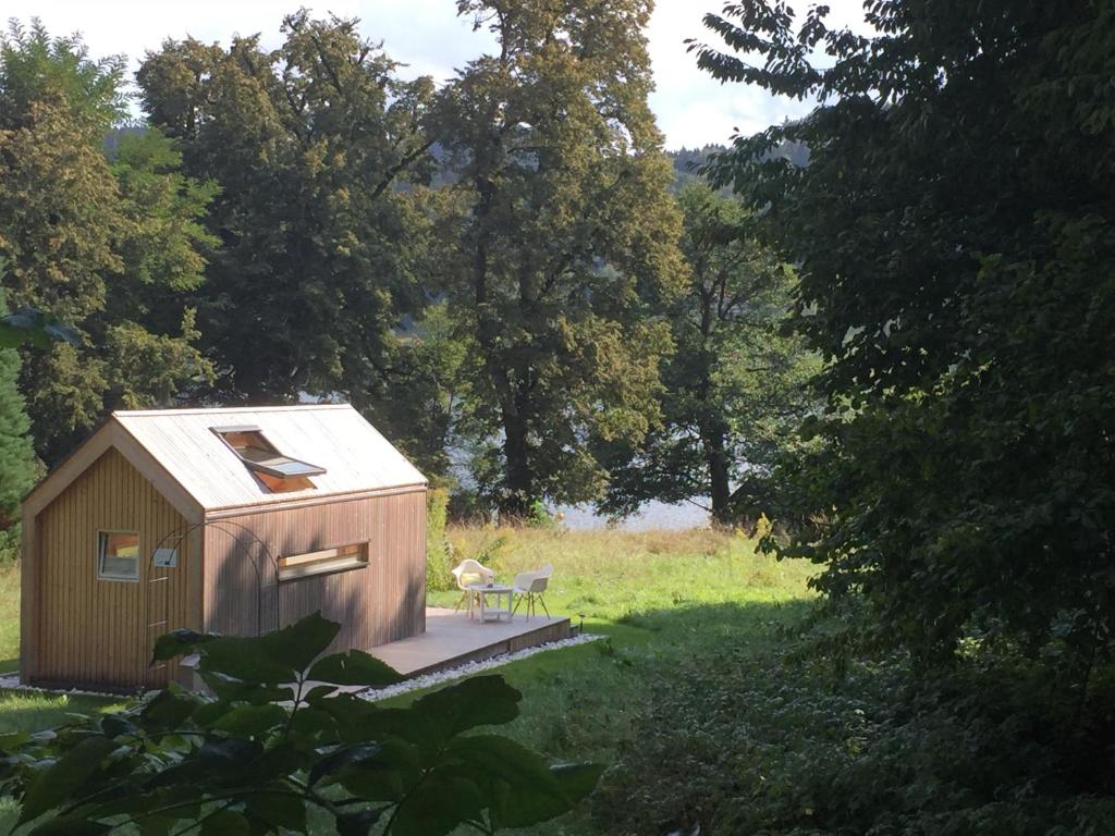 un pequeño cobertizo con un banco en un campo en refugium am see, en Seeboden