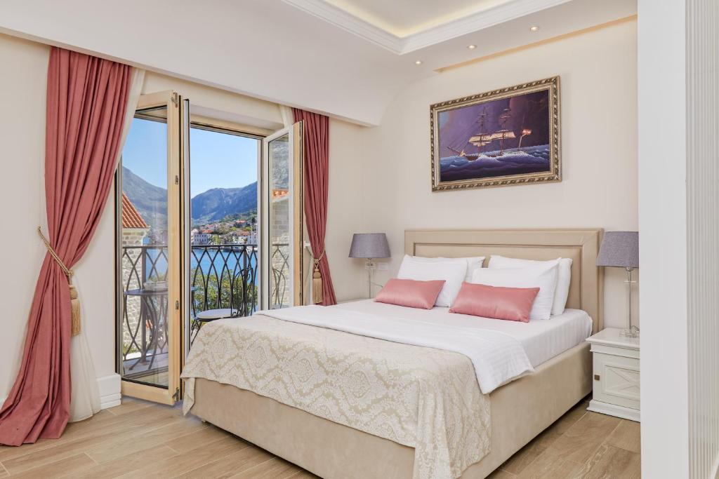 ein Schlafzimmer mit einem Bett und einem Balkon in der Unterkunft Hotel Libertas in Kotor