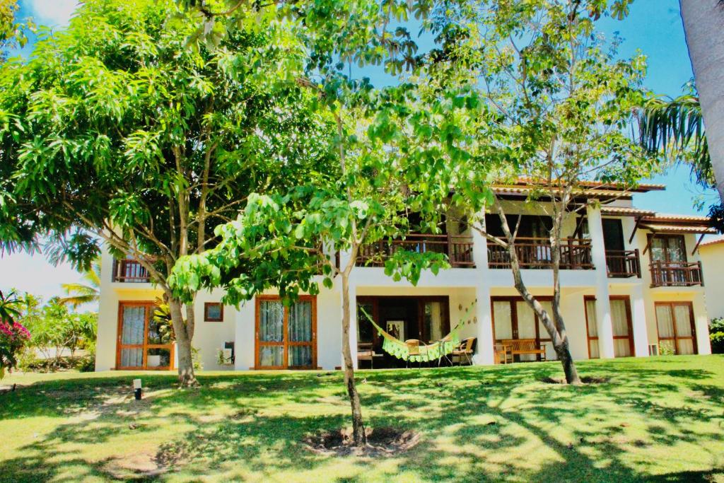 una casa con alberi davanti di Casa Peixinho - Reserva Imbassaí 3 suítes a Imbassai