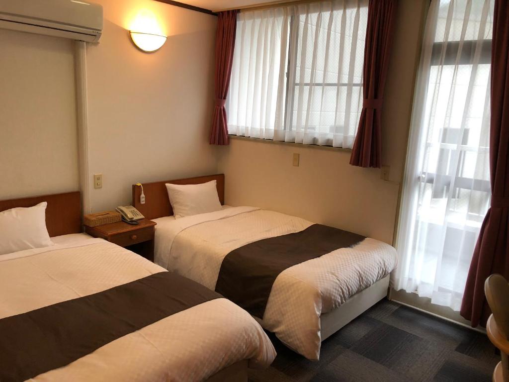 Postel nebo postele na pokoji v ubytování 宇和パークホテル