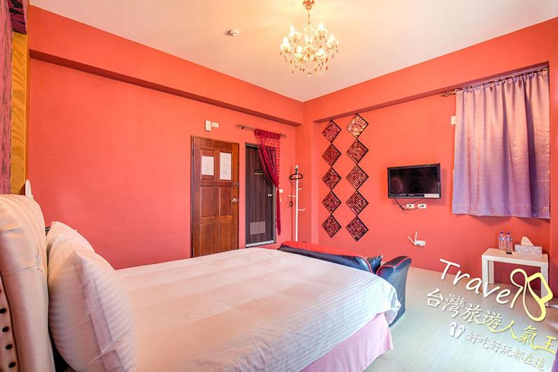 1 dormitorio con paredes de color naranja y 1 cama grande en Fashion Player House en Taitung