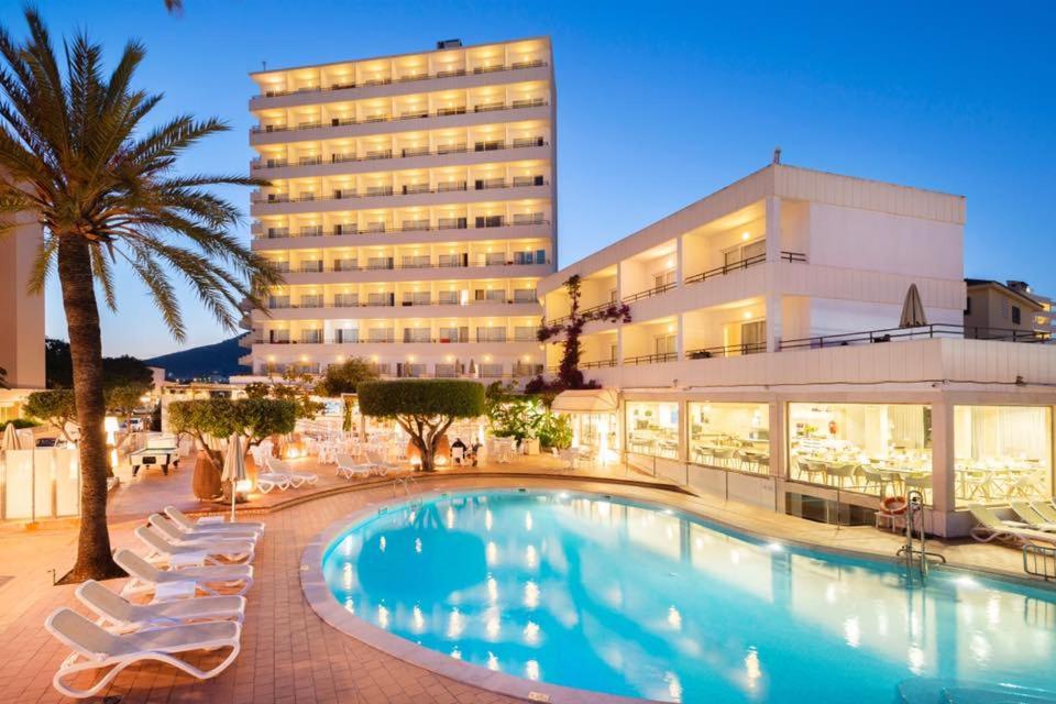 un hotel con piscina frente a un edificio en Hotel Morito, en Cala Millor