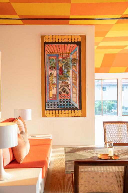 a living room with a couch and a painting on the wall at Cinnamon Bentota Beach - Signature Selection in Bentota