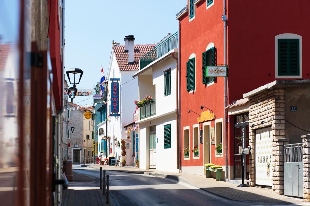 an empty street with colorful buildings in a town at Dida Boža House in Vodice