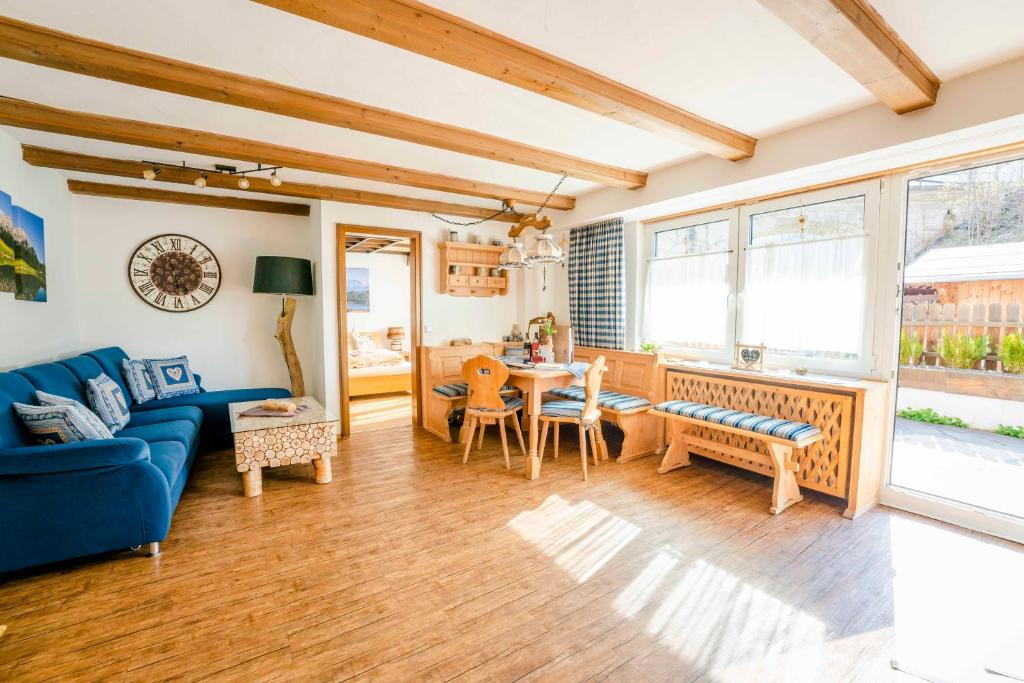 ein Wohnzimmer mit einem blauen Sofa und einem Tisch in der Unterkunft Ferienwohnung Linderspitzblick in Mittenwald
