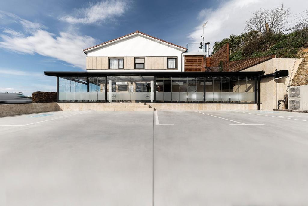 a house with a parking lot in front of it at Pension Residencial Victoria in Santa Cruz de Ribadulla