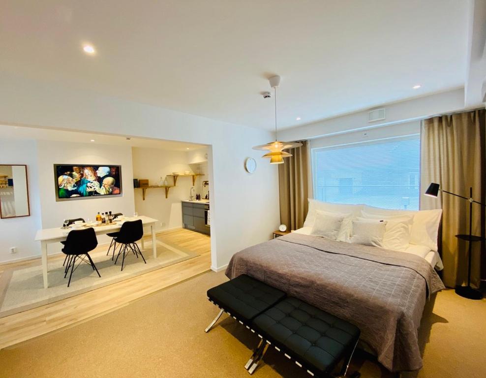 1 dormitorio con 1 cama grande y comedor en Easy Livin' Apartment Hotel en Växjö