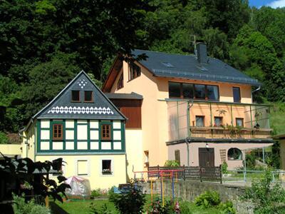 uma grande casa branca com um telhado preto em Ferienwohnungen Herrmann em Bad Schandau