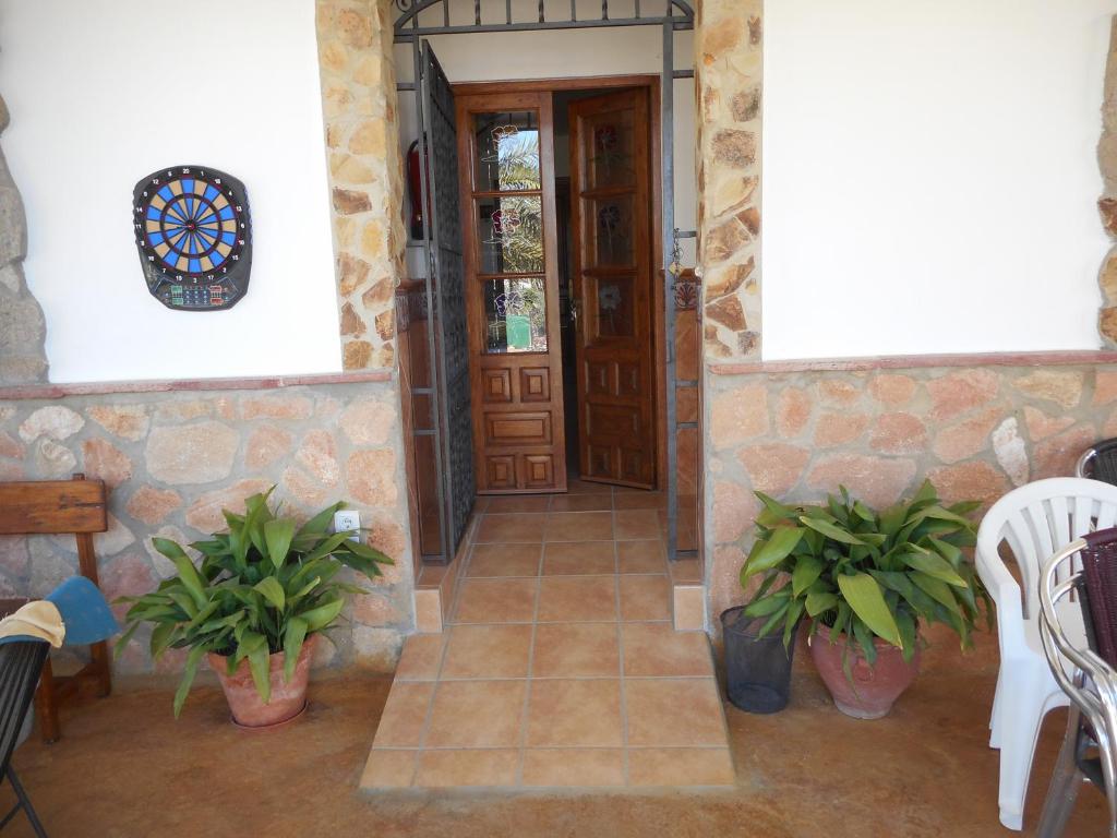 una entrada a una casa con puerta y plantas en Casa Crisal, en Arriate