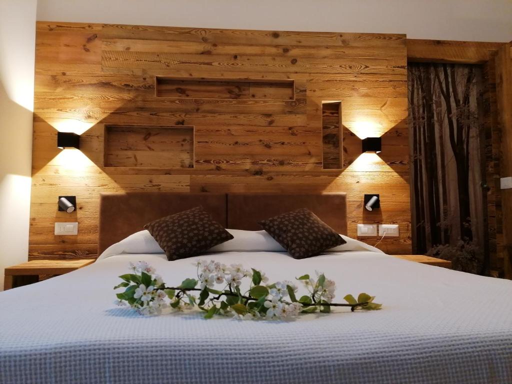 a bedroom with a bed with white flowers on it at Albergo Silvana in Ledro