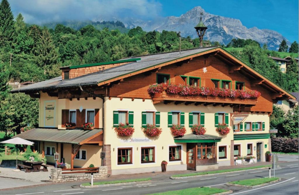 a building with flowers on the balconies on a street at Landgasthof Reitsamerhof in Werfen