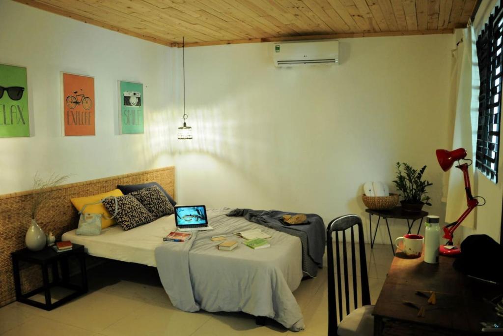 a bedroom with a bed with a laptop on it at Domino Homestay in Ho Chi Minh City