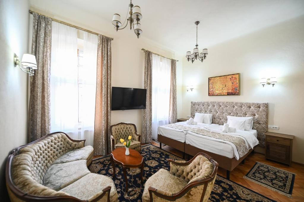 a bedroom with a bed and two chairs at Casa ABA in Sibiu