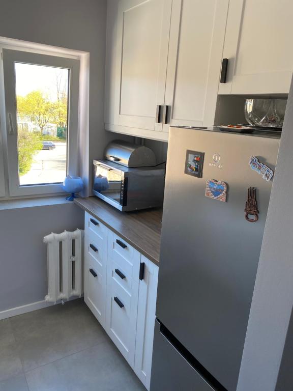 eine Küche mit einem weißen Kühlschrank und einem Fenster in der Unterkunft Apartament Twardowscy in Sopot