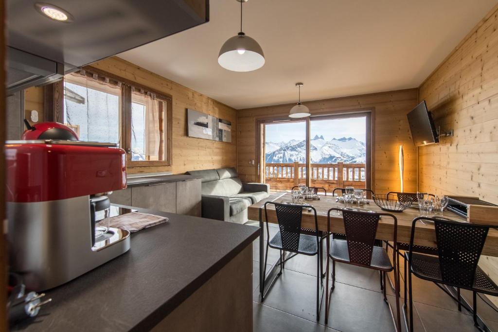 a kitchen with a table and chairs in a room at ODYSSEE B101 - Appartement traversant sur les pistes in La Toussuire