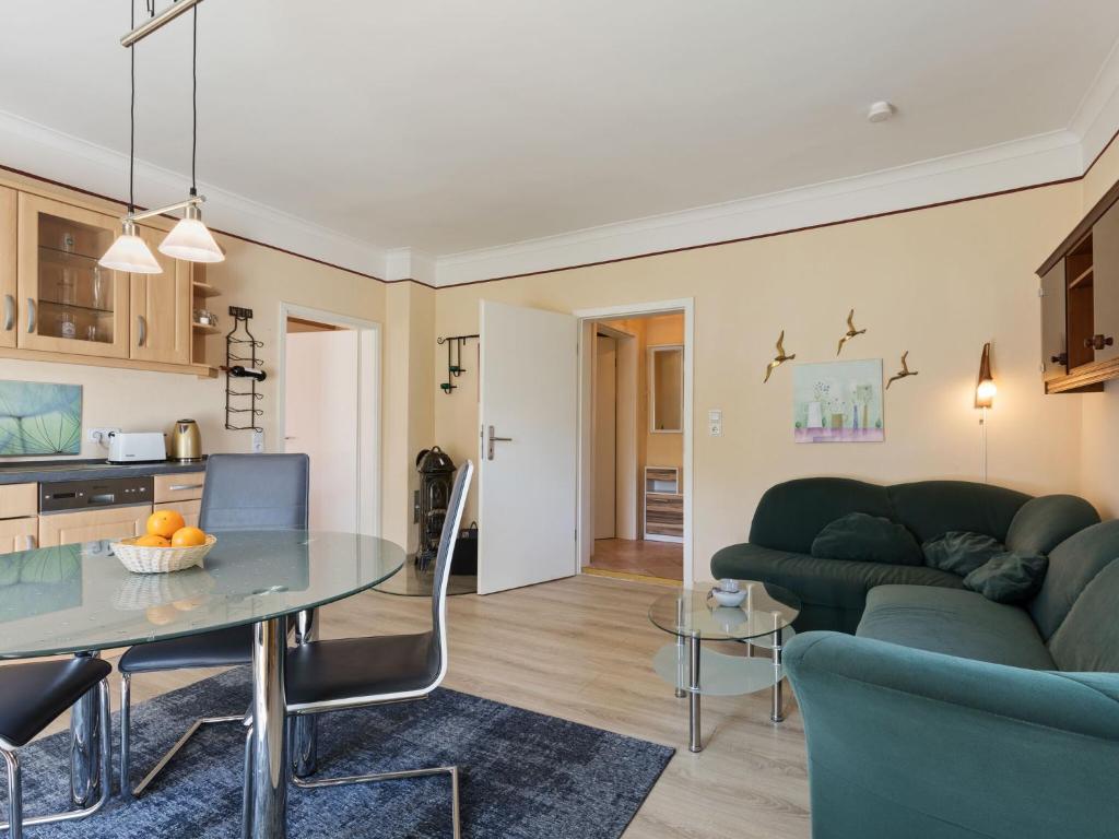 a living room with a green couch and a table at Elegant apartment with garden in Gingst in Gingst