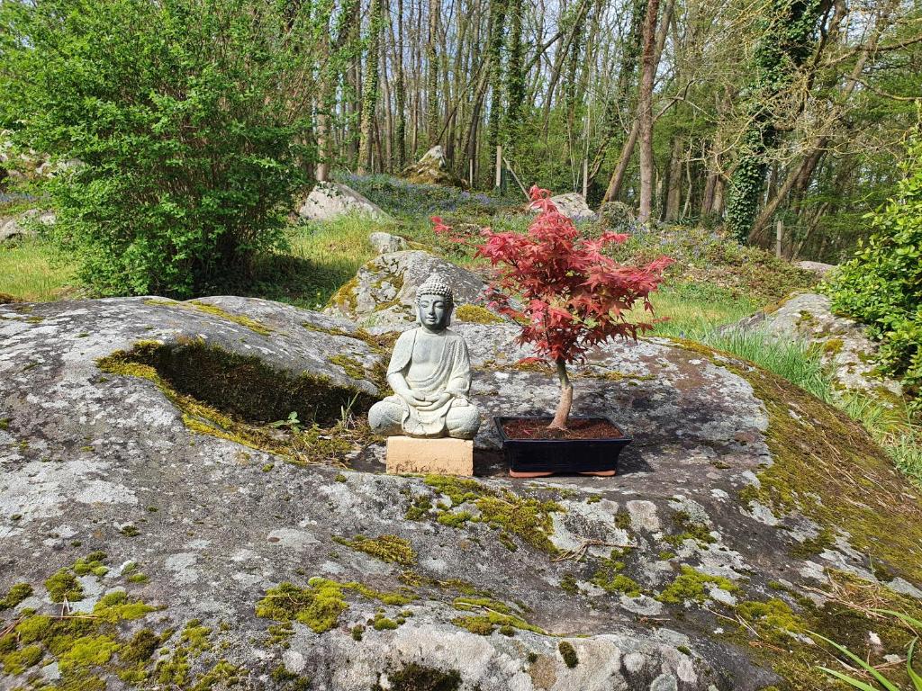 a statue of a woman sitting next to a plant at GITE LES ROCHES in Moigny
