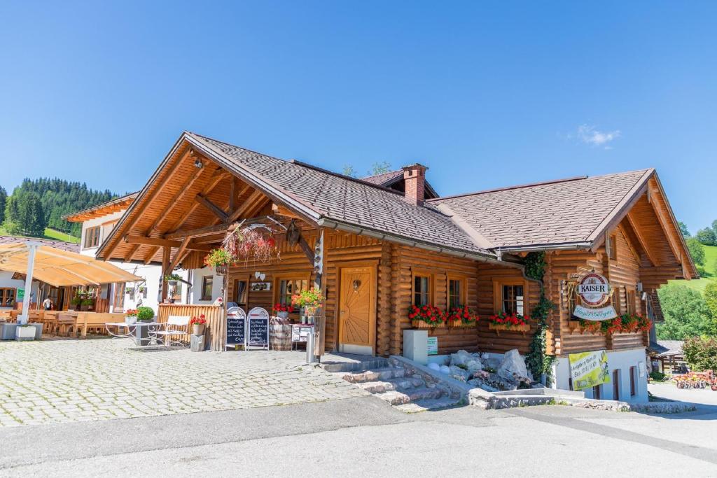 a log cabin building with a patio in front of it at Gasthof Jagersberger in Hollenstein an der Ybbs