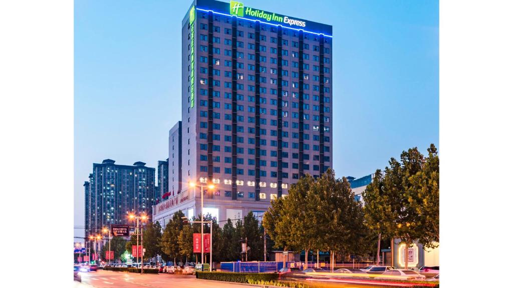 a tall building in a city at night at Holiday Inn Express Shijiazhuang High-tech Zone, an IHG Hotel in Shijiazhuang