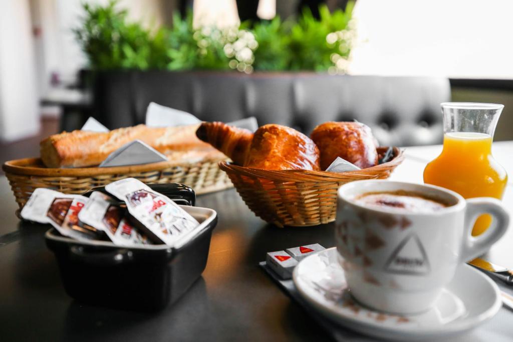 a table with a cup of coffee and a basket of pastries at Hostellerie LE PANEL in Mandelieu-La Napoule