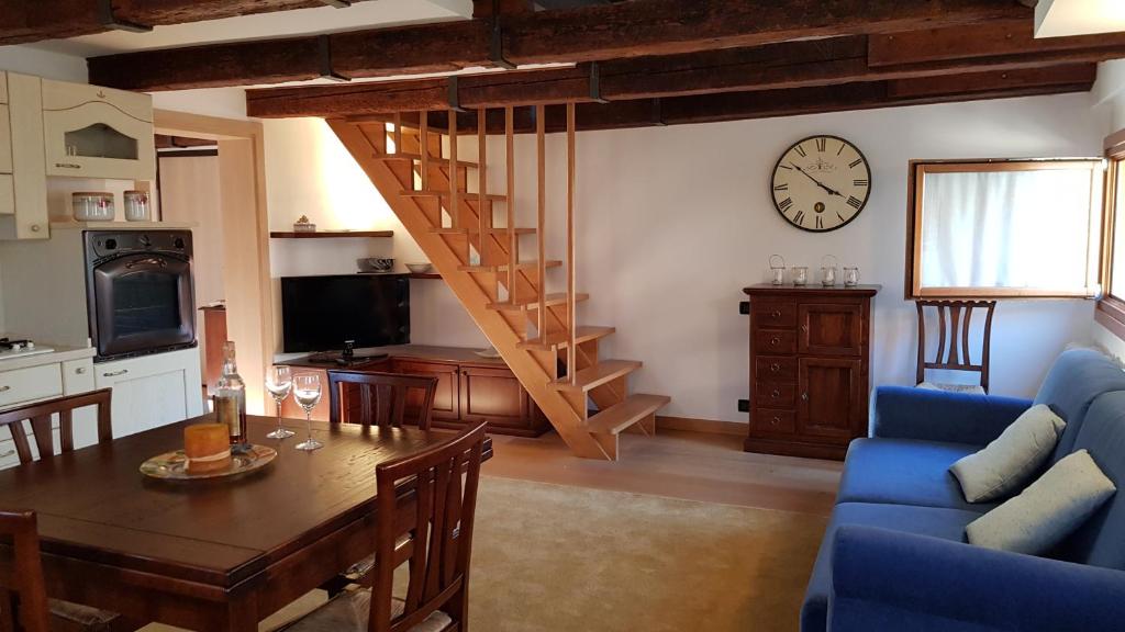 salon ze stołem i zegarem na ścianie w obiekcie WellVenice Altana Top View w Wenecji