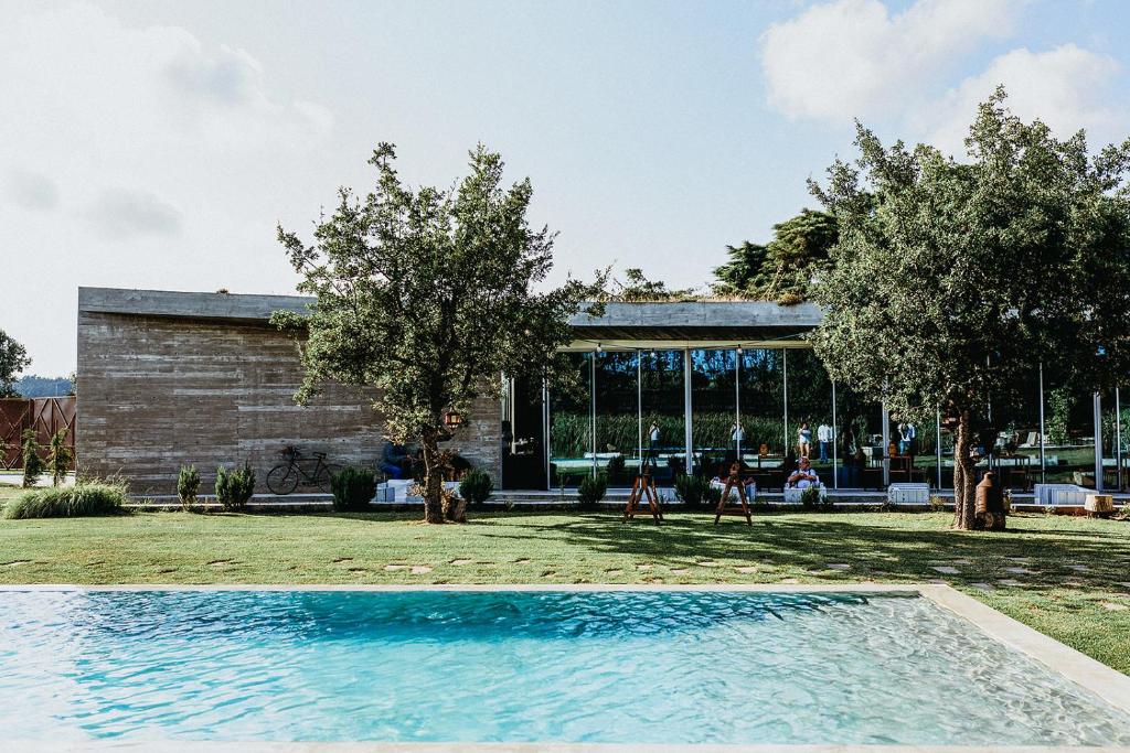 uma piscina em frente a uma casa com árvores em Rio do Prado em Arelho