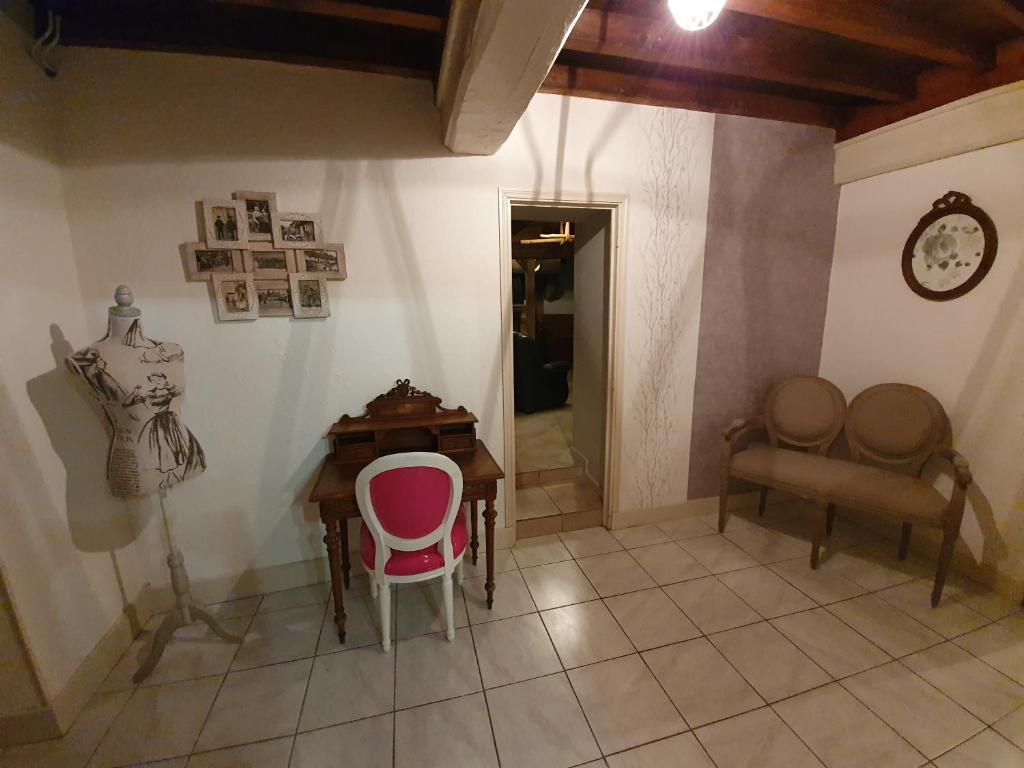Habitación con escritorio, silla y mesa. en le coq du morvan, en Bussières