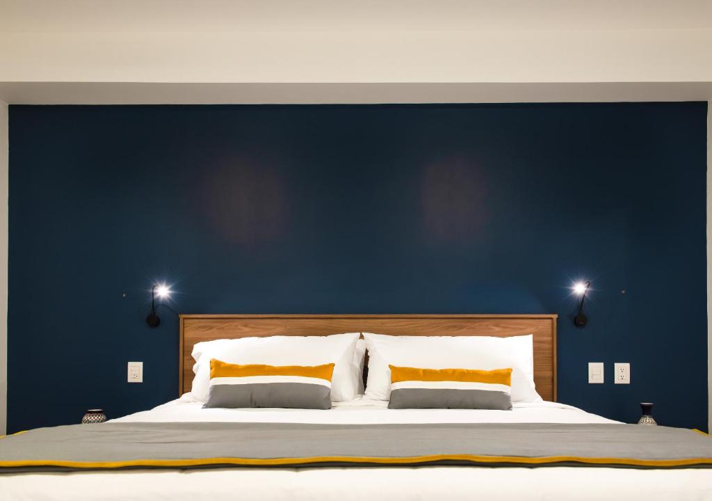 a bedroom with a large bed with a blue wall at Hotel Boutique Parque Centro in Mexico City