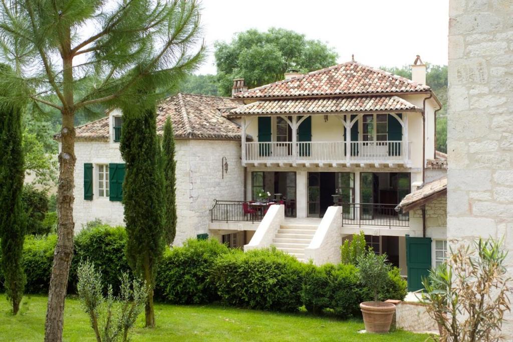 a large white house with a porch and stairs at Domaine de Saint-Géry - Teritoria in Lascabanes