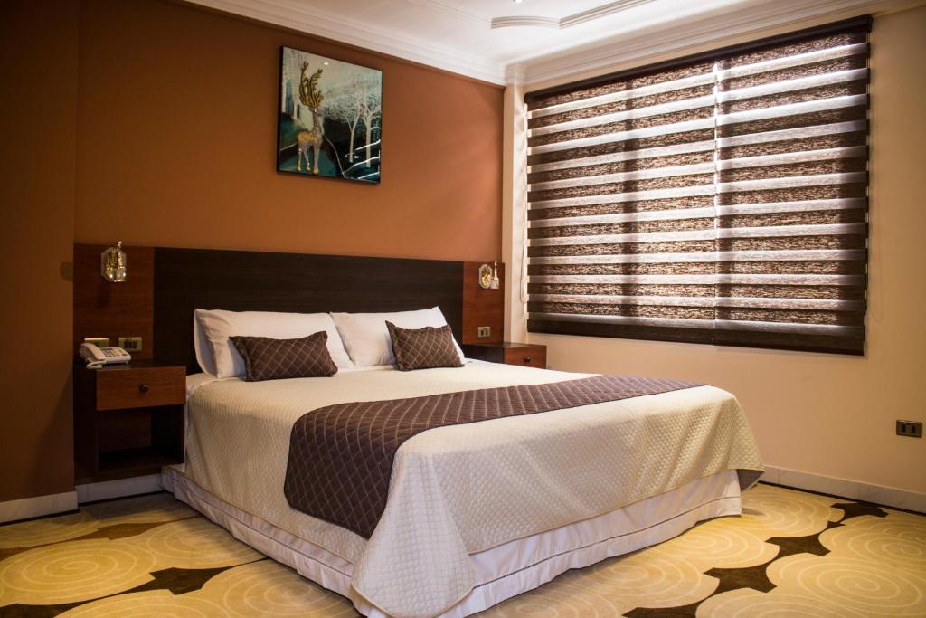 um quarto com uma cama grande e uma janela em Hotel Pairumani em Cochabamba