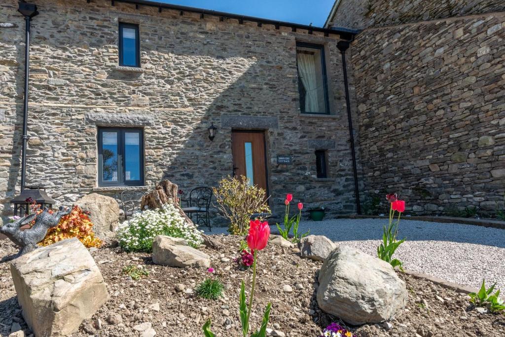 a stone house with a garden in front of it at Drovers Cottage in Kendal