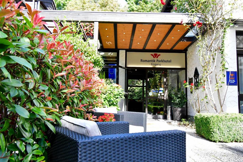 two blue wicker chairs sitting in front of a store at Romantik Parkhotel am Hammerberg in Stolberg