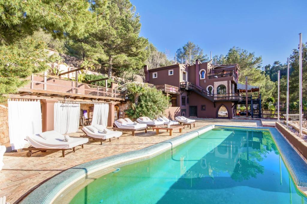 an outdoor swimming pool with lounge chairs and a house at Casa Blanca in Sant Miquel de Balansat