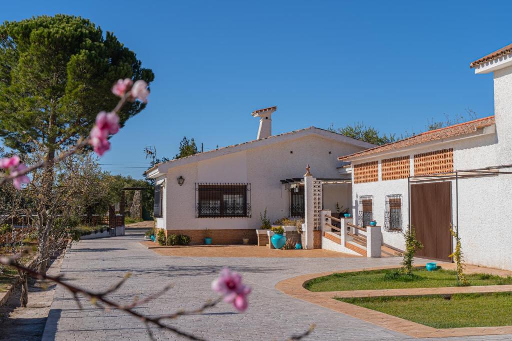 una casa con un árbol floreciente delante de ella en Recreo San Andrés, en Ronda