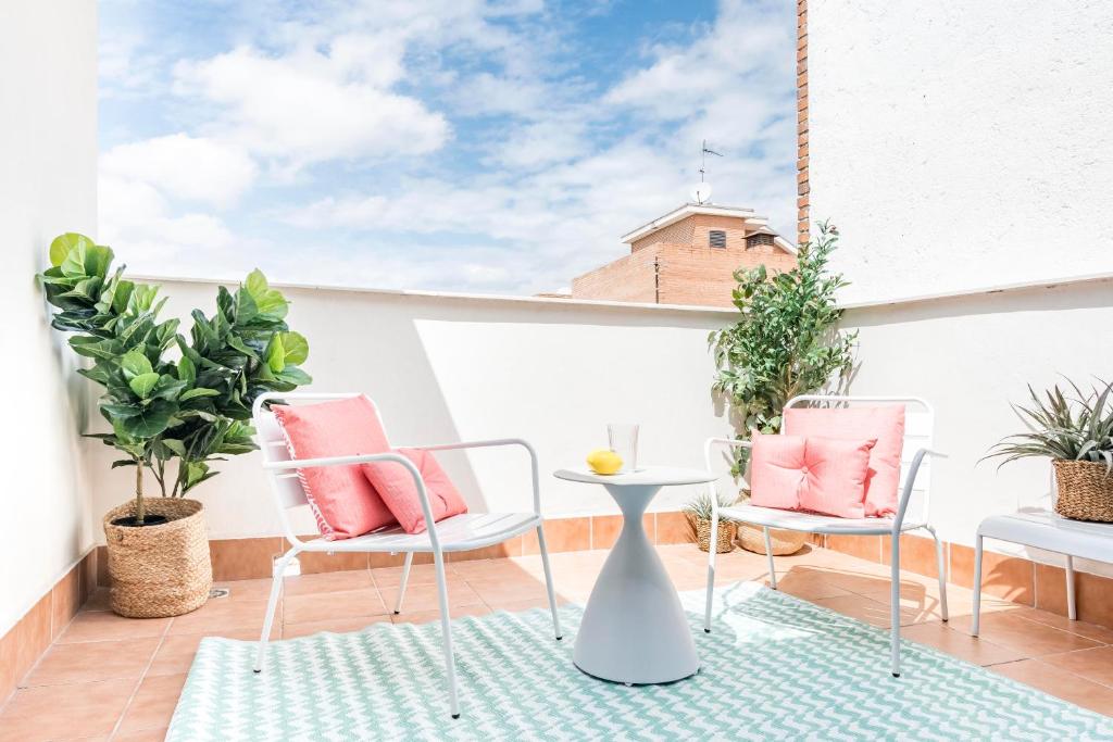 um pátio com 2 cadeiras e uma mesa na varanda em Cool Apartments by Olala Homes em Madrid