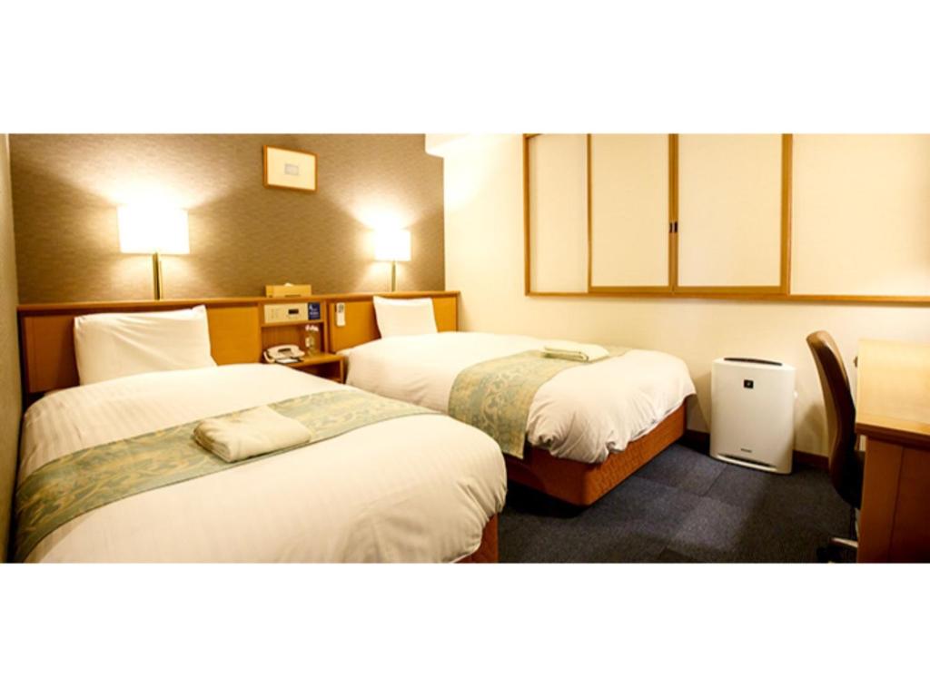 een hotelkamer met 2 bedden in een kamer bij Hakata Floral Inn Nakasu / Vacation STAY 80214 in Fukuoka
