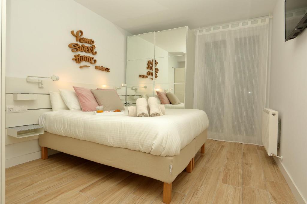 a white bedroom with a large bed with a mirror at Home Sweet Home Main St Pamplona in Pamplona