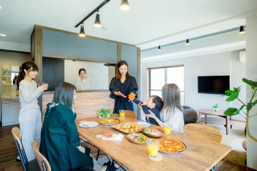 熊本的住宿－Kumamoto - Apartment / Vacation STAY 81139，一群坐在餐桌旁吃食物的妇女