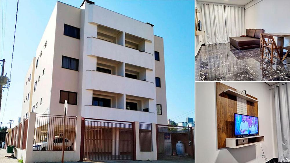 ein weißes Gebäude mit einem TV davor in der Unterkunft Edifício Louise – Apto 301 in Chapecó